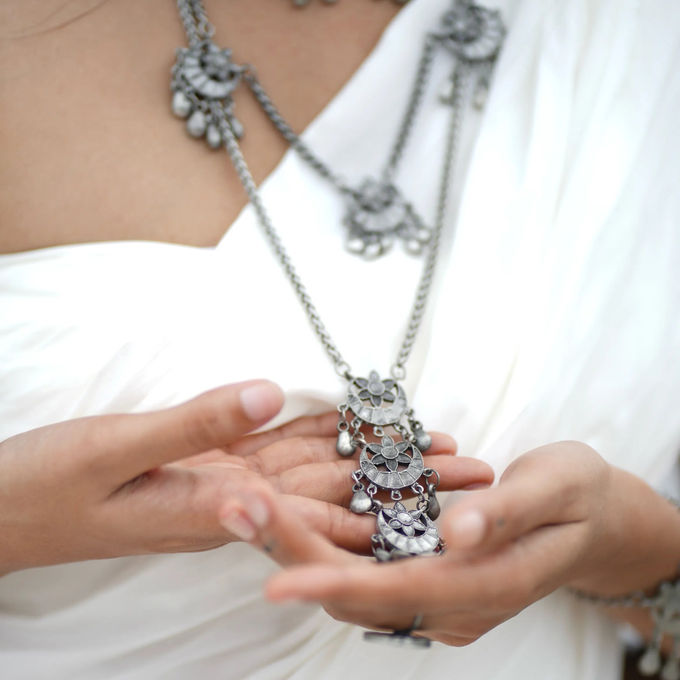 Chandrapushpa oxidised brass tribal pendant necklace with multiple engraved motifs and dangling charms