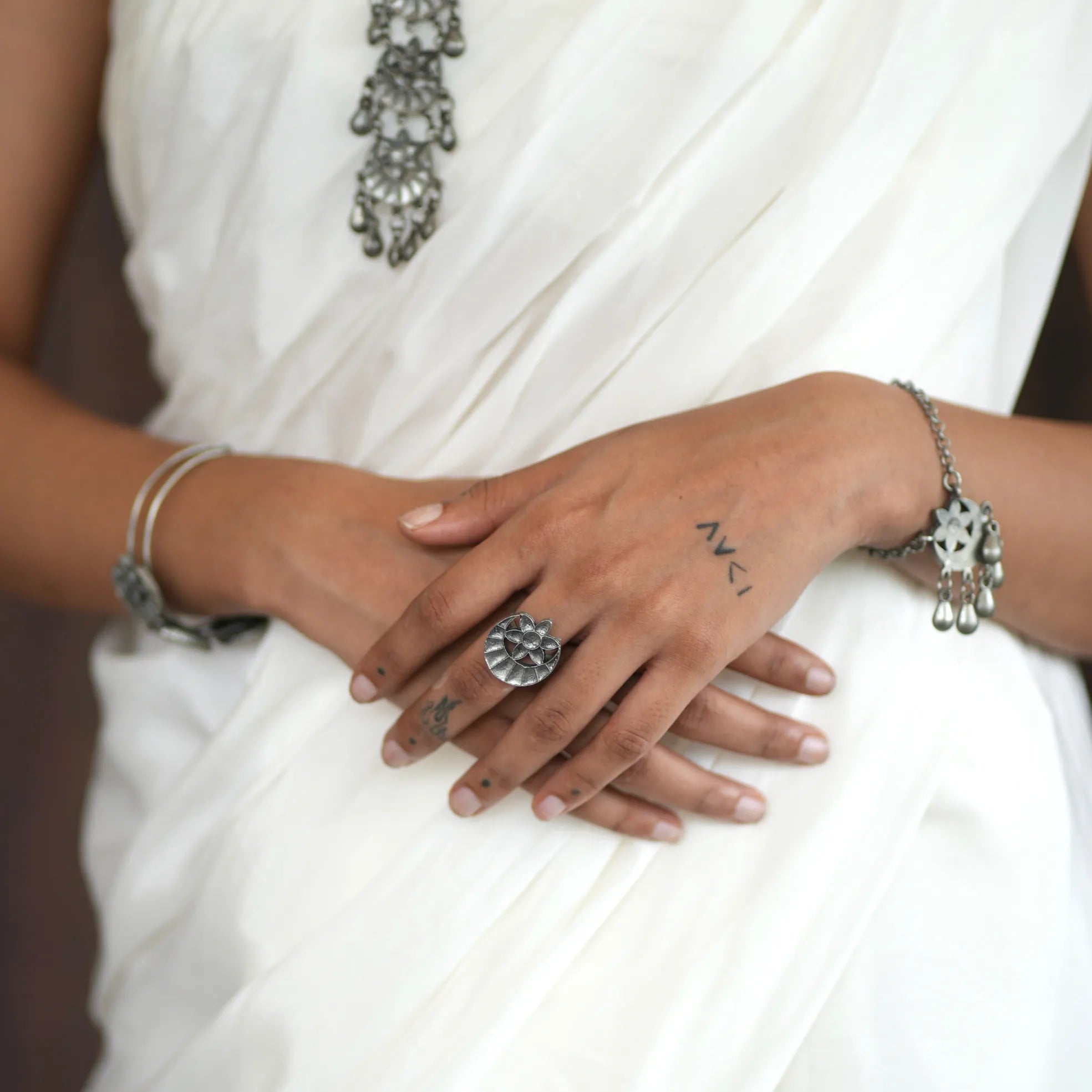 Chandrapushpa oxidised brass tribal ring with engraved motif and draped chain styling