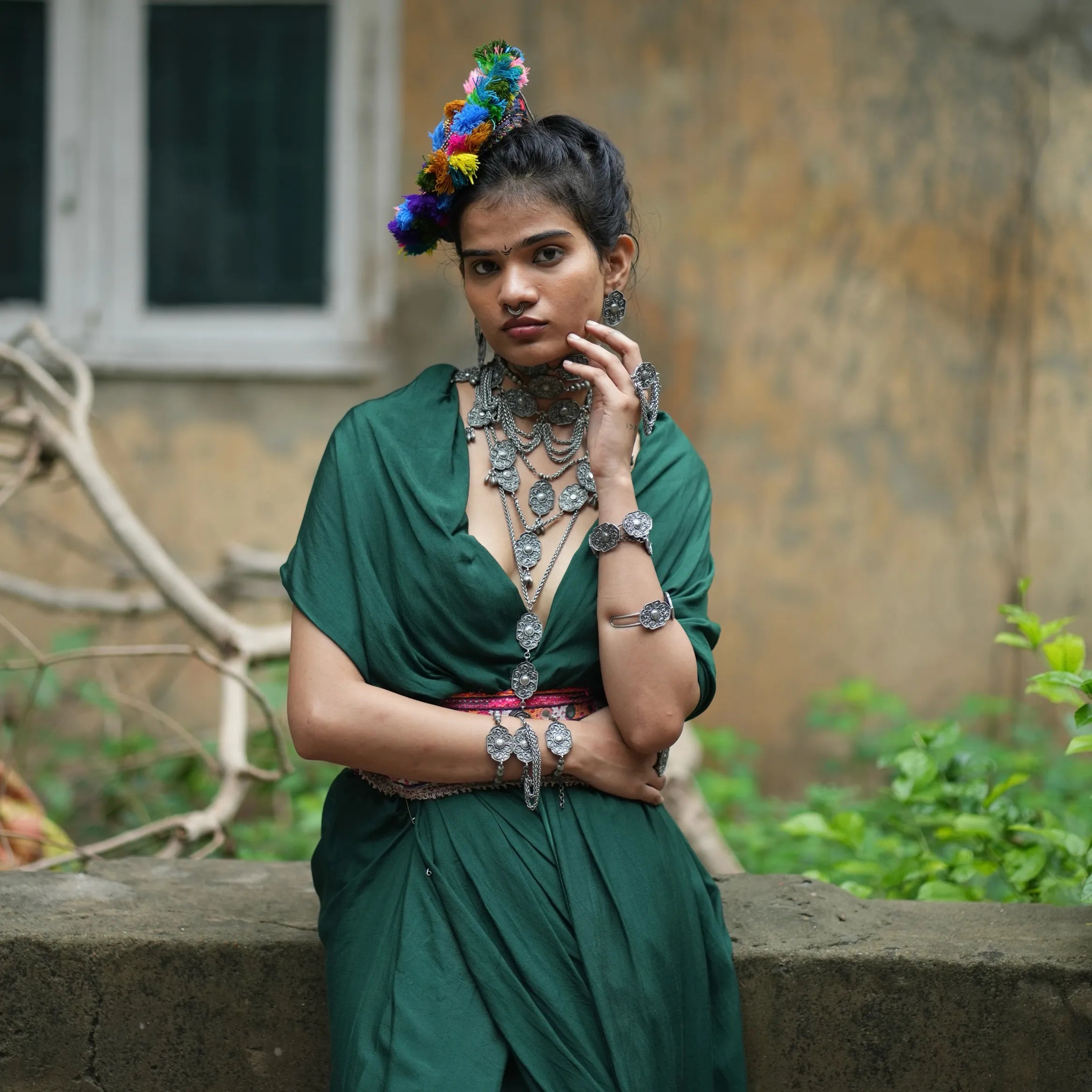 Model wearing Rekha necklace styled with layered tribal jewelry in green ethnic attire